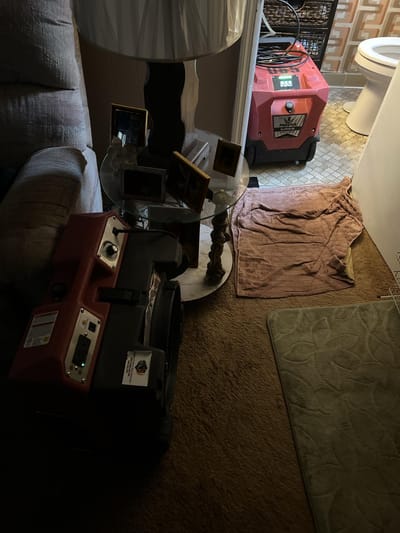 A dehumidifier running in the bathroom to stabilize the space while abatement was scheduled