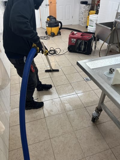 Vacuuming standing water off the prep room's tile floor
