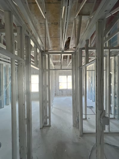 A room stripped to the studs with the framing sealed in white encapsulant to lock in smoke odor