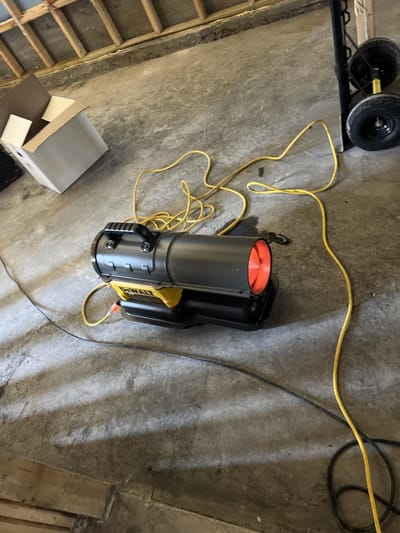 Space heater keeping the gutted, unheated home workable through the winter