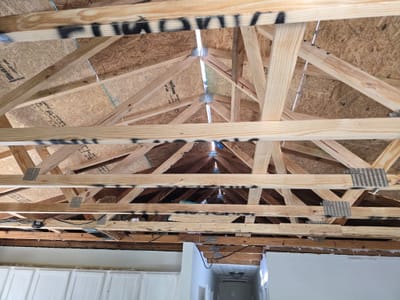 New roof trusses and decking framed in above a home during reconstruction
