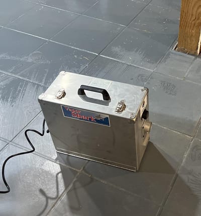 A vapor-phase deodorizing machine set up on a tiled floor to neutralize odor