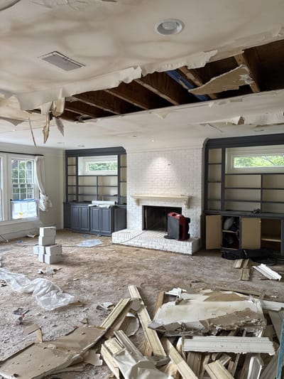Emptied, packed-out room with its ceiling torn open by the water damage