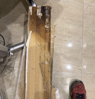 Removed baseboard and drywall with mold and water staining on the back
